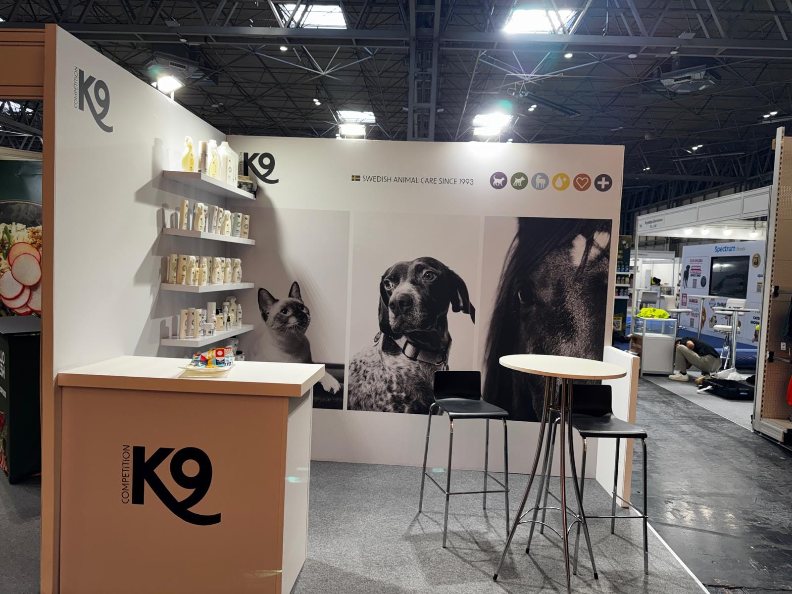 Branded K9 reception desk and display shelving on the K9 Competition stand at PATS 2026