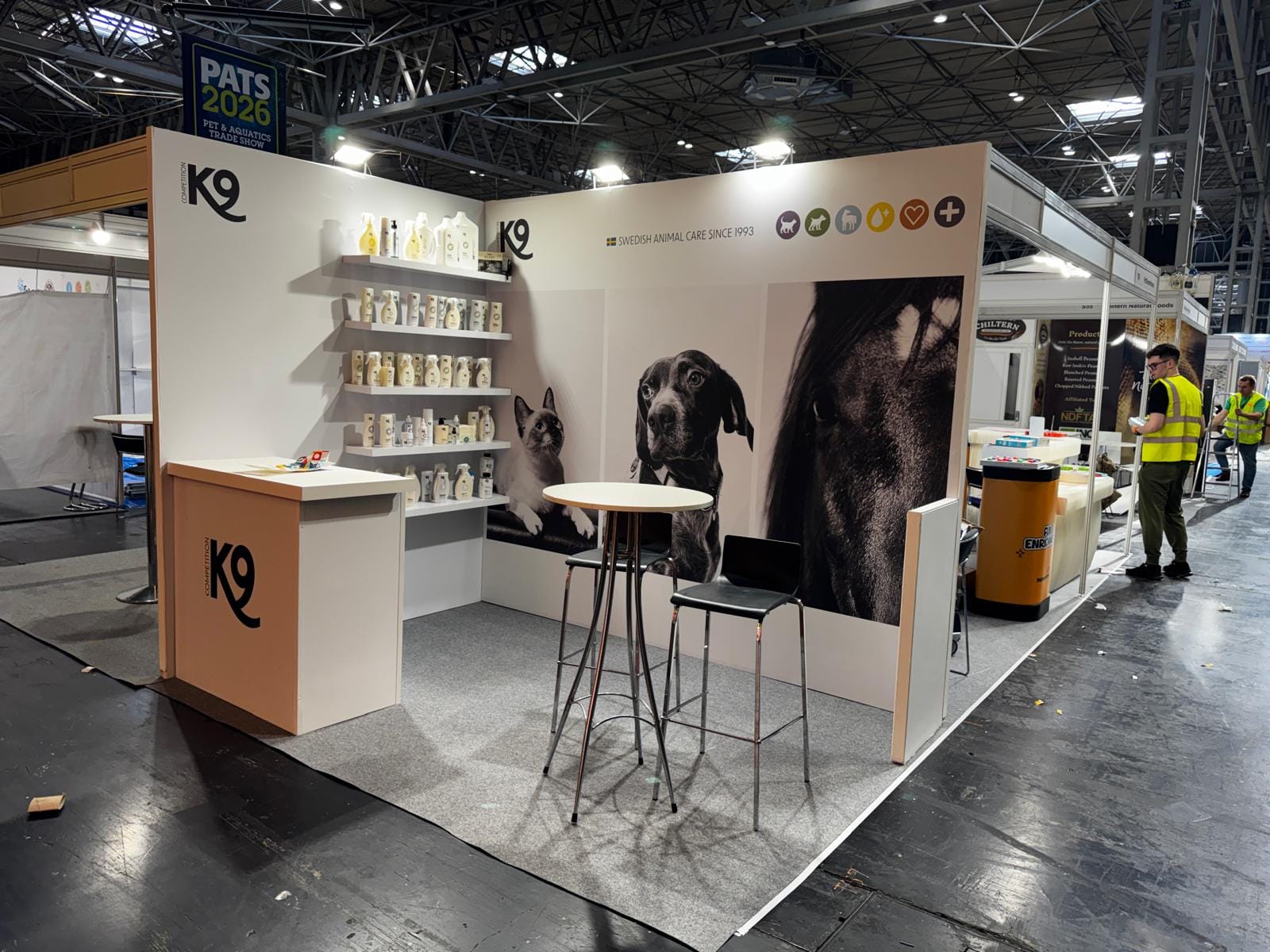 K9 Competition stand with product shelving and graphic-wrapped walls at PATS 2026
