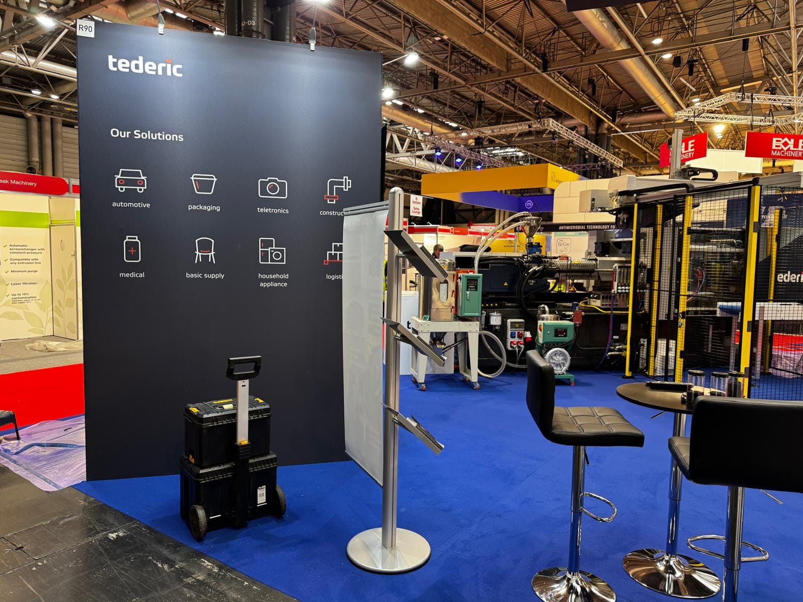 Tederic Our Solutions totem wall with bar stools on the Interplas stand